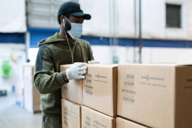 A volunteer stacks International Paper community boxes at a food bank